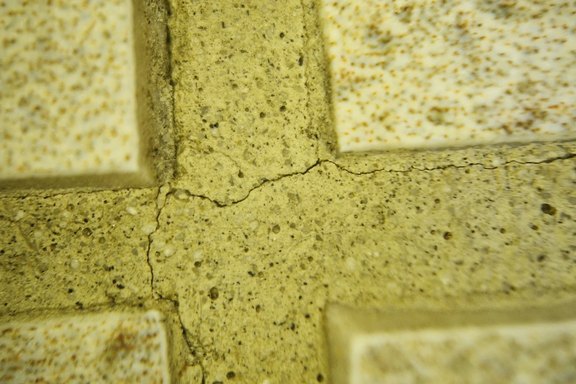 Nahaufnahme - Risse und/oder Flankenabrisse vom Zementfugenmaterial zu keramischen Platten